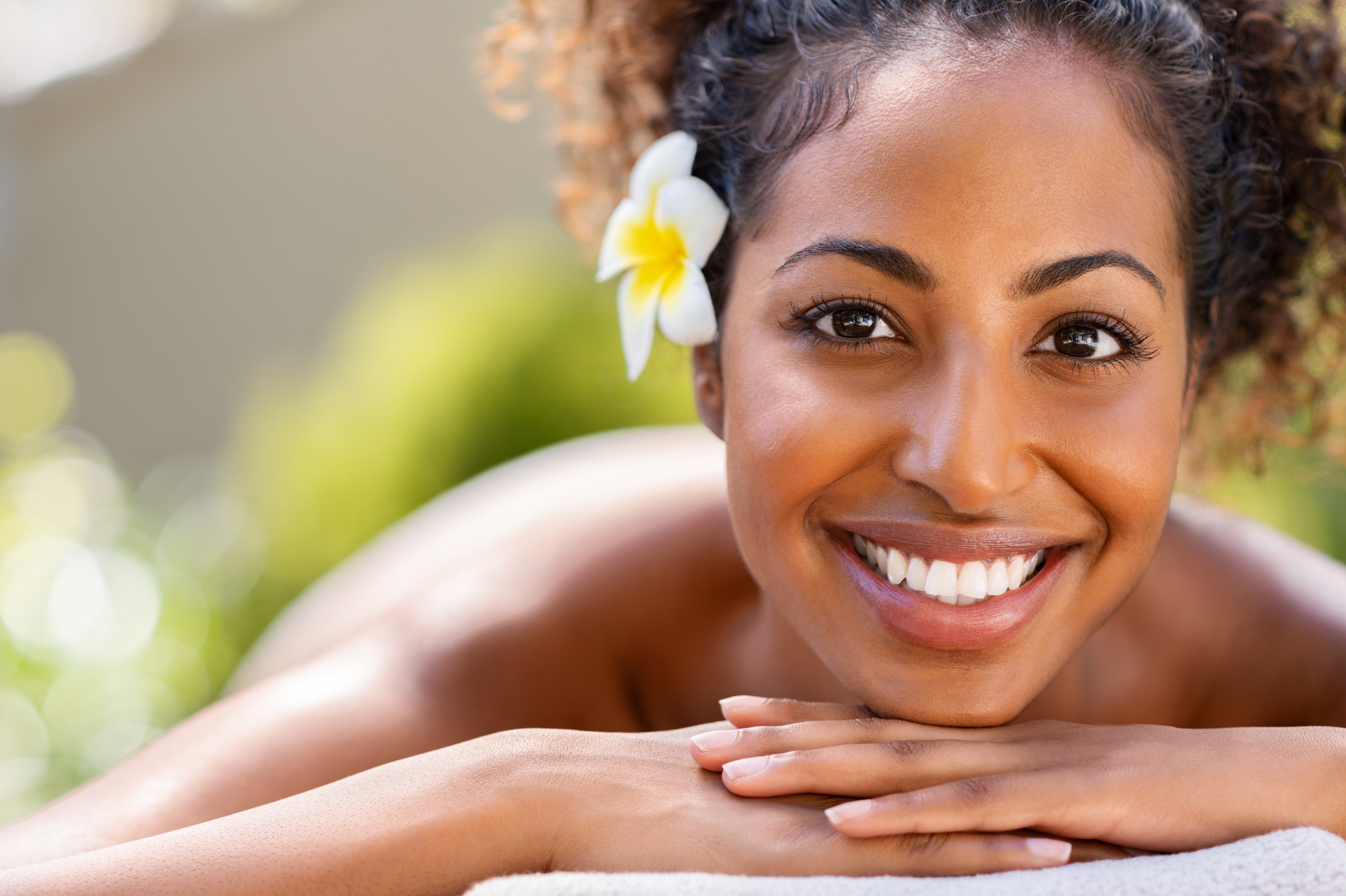 Beauty african woman lying on massage table at spa